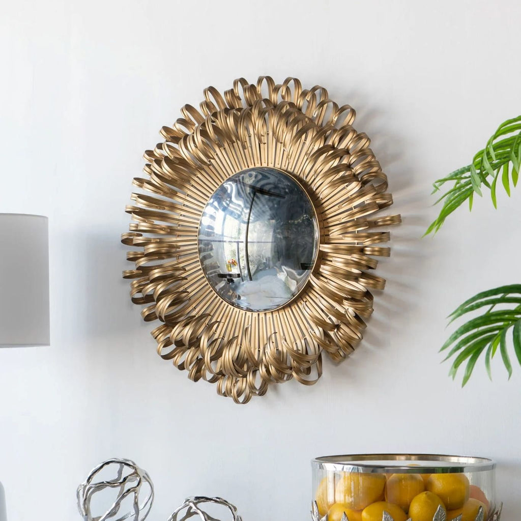 Bérénice Mirror shown in a styled interior, demonstrating the 27-inch sunburst scale as a compact gold wall accent.