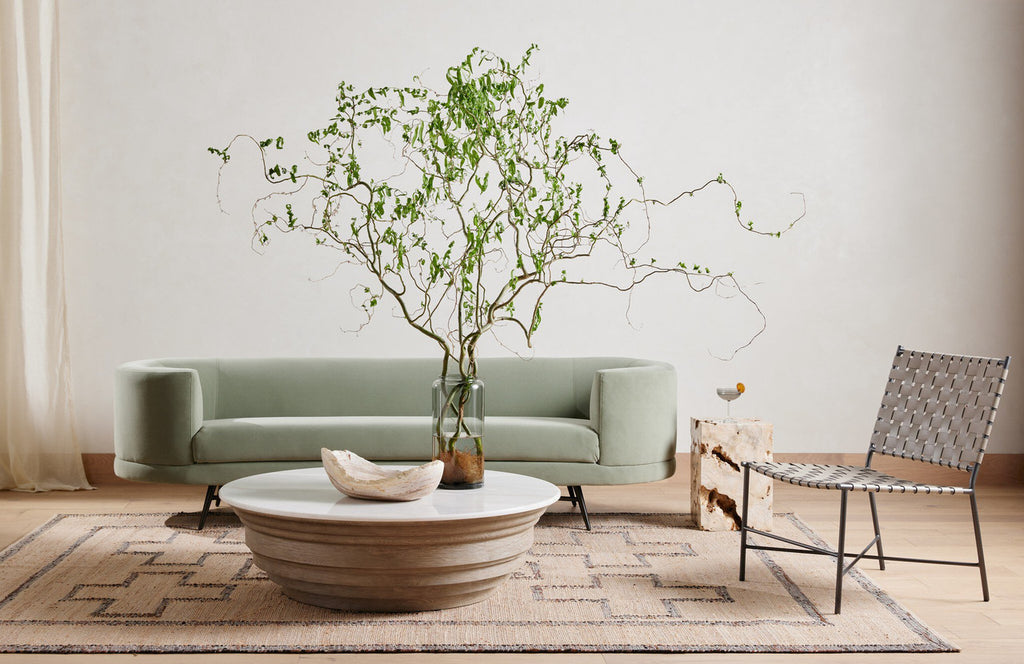 The Palu Accent Table in solid Romano Fosse travertine, showing its compact monolithic form and naturally porous stone surface.