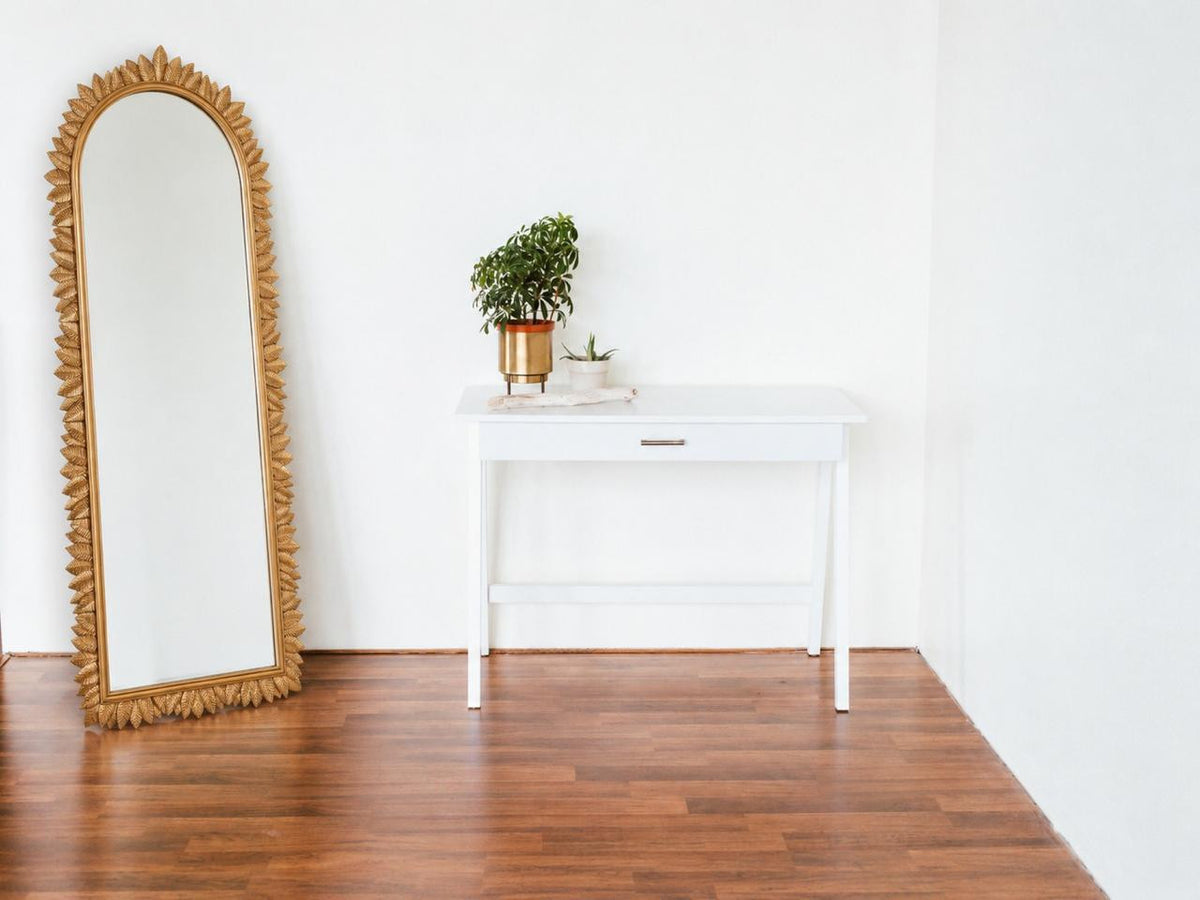 Detail view of the Palmette Arch Mirror emphasizing the sculpted botanical metal frame in gold.