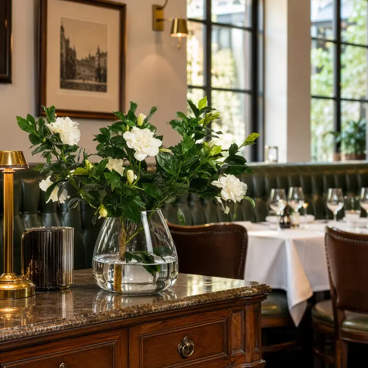 Sylvie Gardenia Arrangement styled on a polished wood sideboard in a warmly lit dining interior.