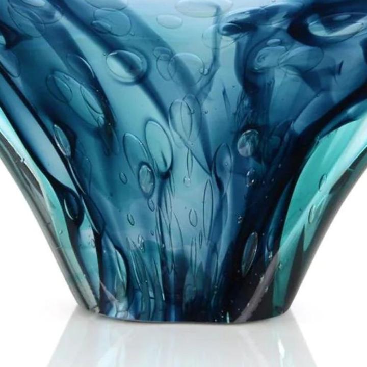 Close lower detail of The Océane Sculpture showing deep sapphire folds, turquoise edges, and air bubbles within the glass.