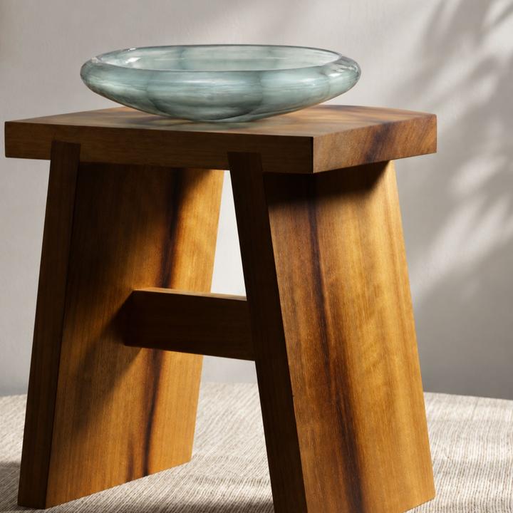 Marine Glass Bowl displayed on a sculptural wood stool in a bright neutral interior.