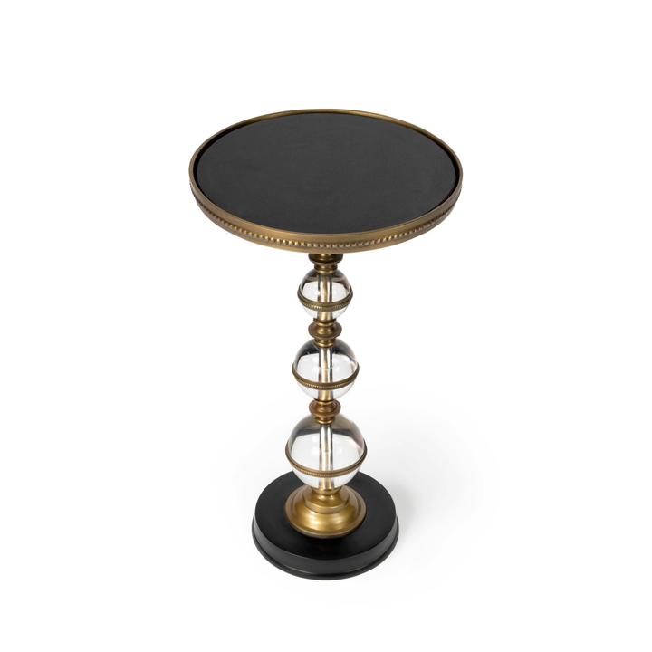 Full view of the Béatrice Pedestal Side Table with a round black granite top, bronze-finished trim, stacked clear acrylic spheres, and black circular base.