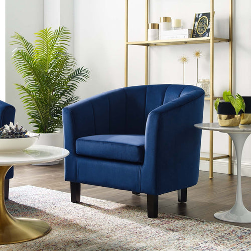 Storm-blue velvet curved armchair placed beside a marble-top side table in a modern living room
