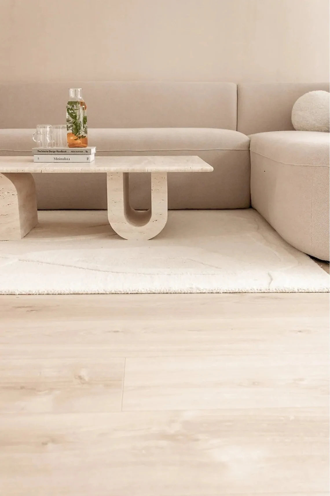 Close-up of travertine U-shaped table leg showing natural stone veining