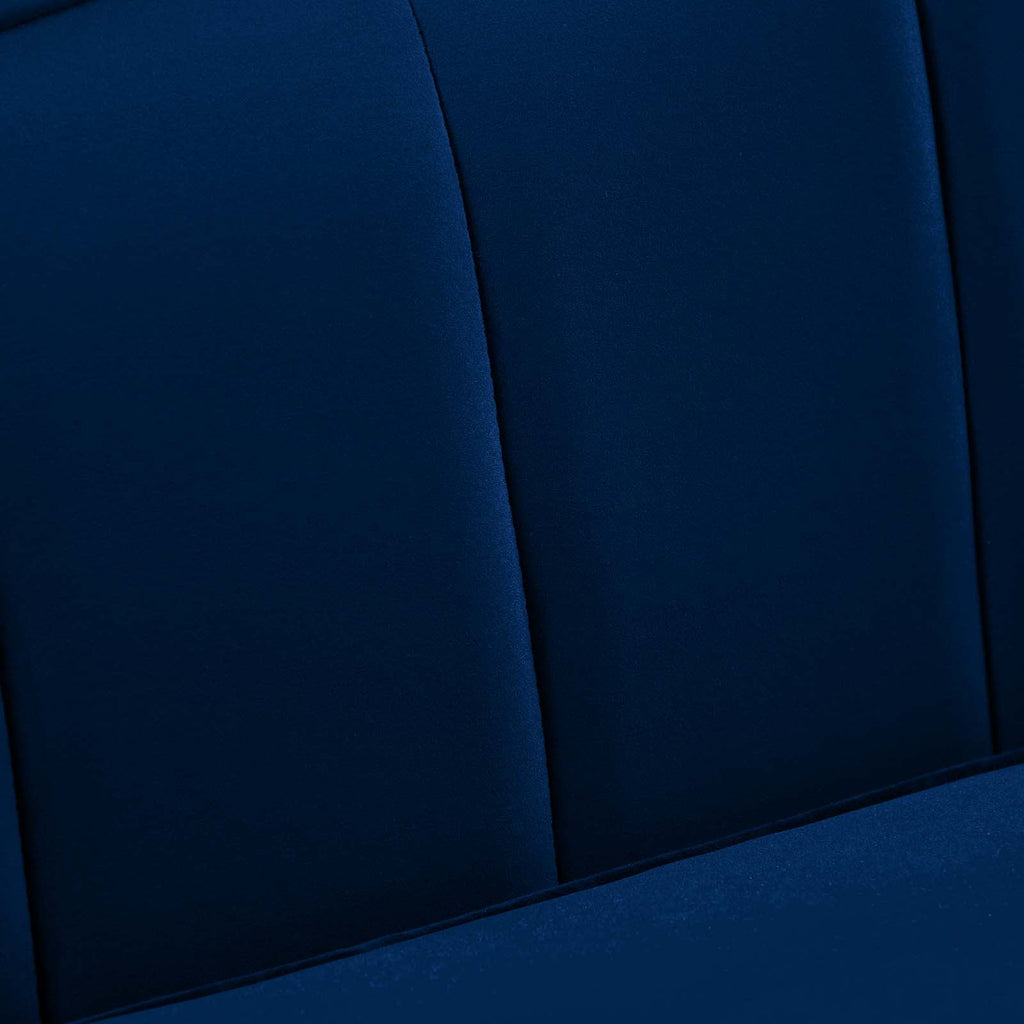 Macro detail of navy velvet channel tufting texture and stitched seams on the Bernadette Sofa's backrest