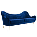 Navy blue velvet sofa with channel-tufted curved back and tapered brushed gold legs, three-quarter view