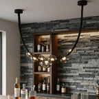 Black leather strap chandelier with smoked glass globes styled above a bar counter