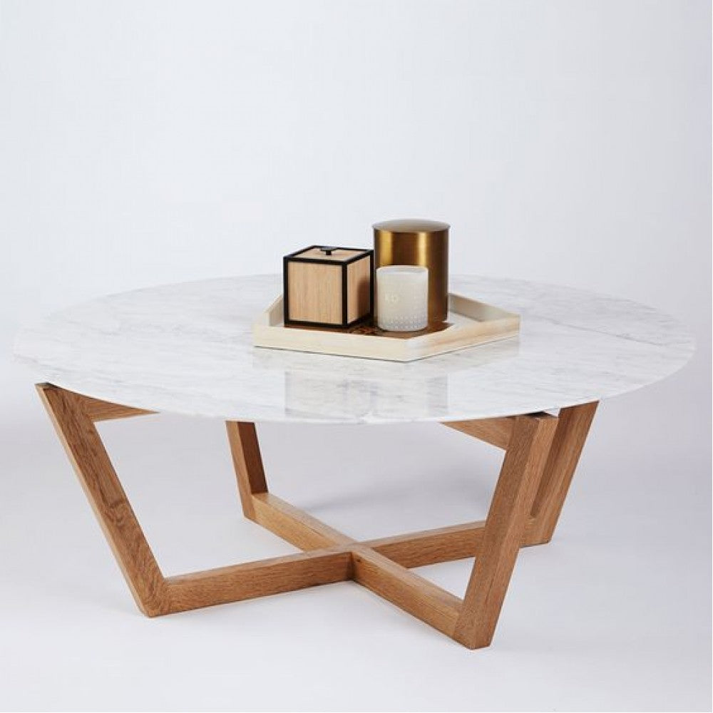 Round white marble coffee table with crossed walnut wood legs styled with a tray of candles