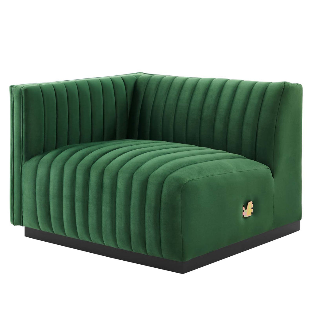 Clean three-quarter studio presentation of the Velvet Rogue emerald green velvet loveseat, highlighting the continuous vertical channel tufting and the hidden black plinth base against a white backdrop.