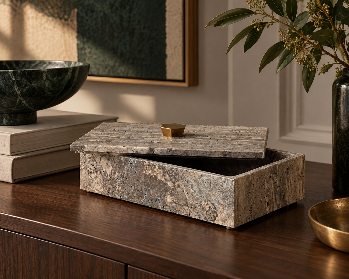 The Augustin Travertine Box styled in a refined contemporary interior, showing its realistic scale and material character in room context.