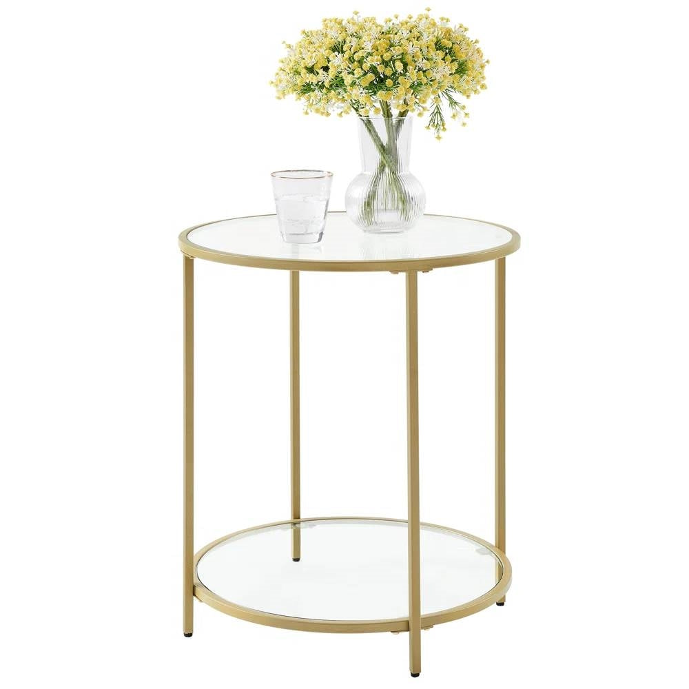 The Joséphine Side Table in glass and gold, styled with a vase of flowers and a drinking glass on the top tier.