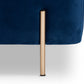 Close-up of the Lina Storage Bench's slender brushed-gold metal leg against navy velvet upholstery