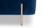 Close-up of the Lina Storage Bench's slender brushed-gold metal leg against navy velvet upholstery