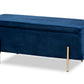 Navy blue velvet storage bench with closed lift-top cushion and slim brushed-gold legs, front three-quarter view