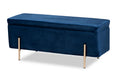 Navy blue velvet storage bench with closed lift-top cushion and slim brushed-gold legs, front three-quarter view