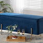 Navy velvet Lina Storage Bench styled in a living room with a woven planter, area rug, and gold serving tray