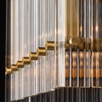Close-up of glass rods and gold connector hardware on a linear chandelier