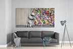 Glass triptych wall art displayed above a gray sofa in a modern living room