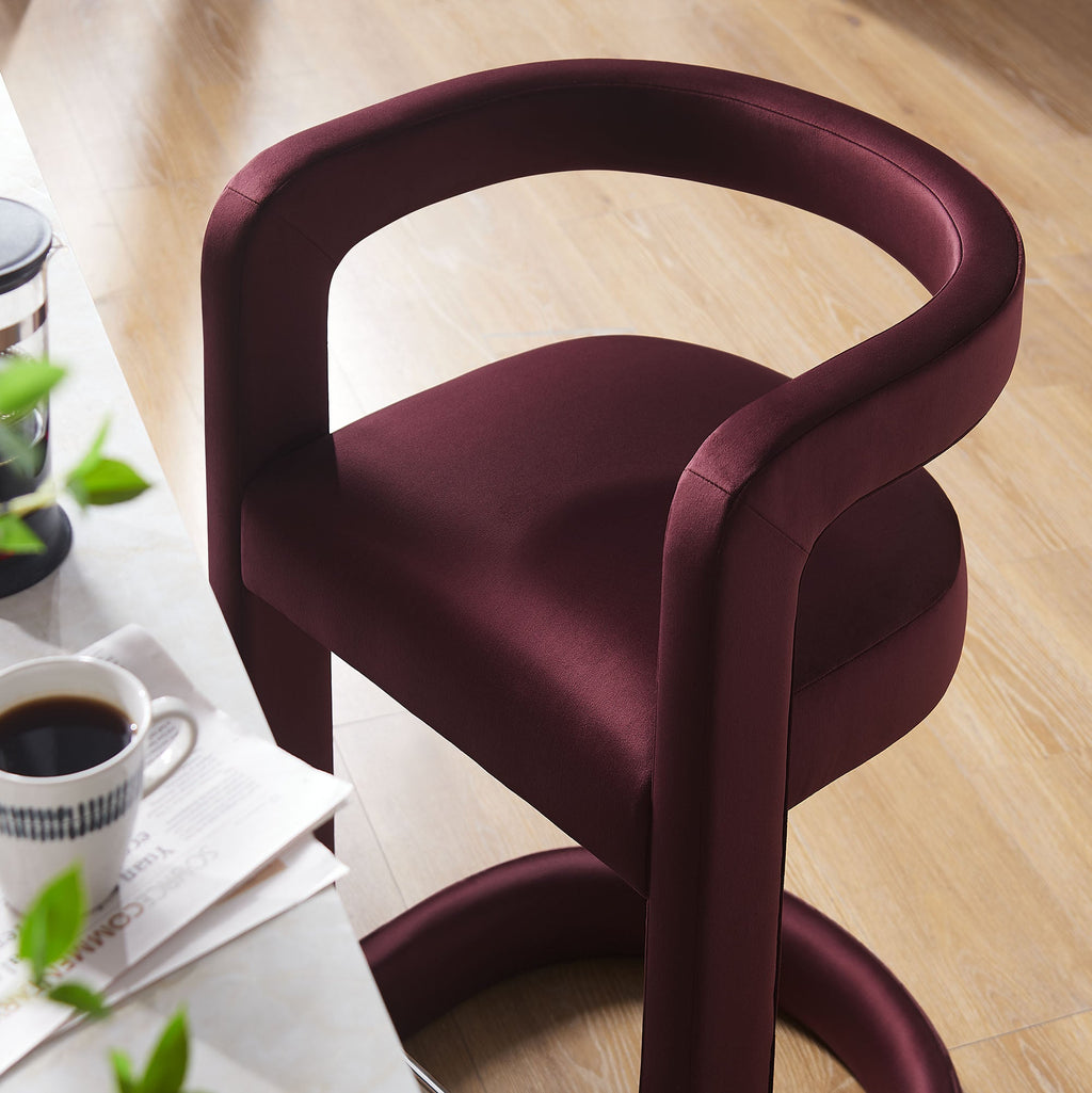 Overhead close-up of aubergine velvet counter stool seat and backrest curve in a kitchen setting