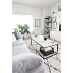 Marble coffee table with black frame and woven basket styled in a gray living room