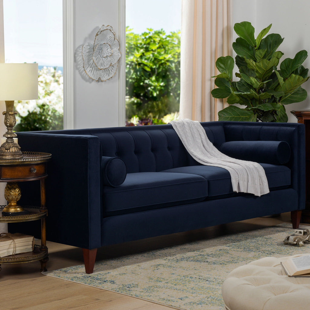 Minimalist 84-inch sofa from the Cadence collection featuring a crisp tuxedo silhouette and tapered accent legs in dark navy . Three quarter view in living room