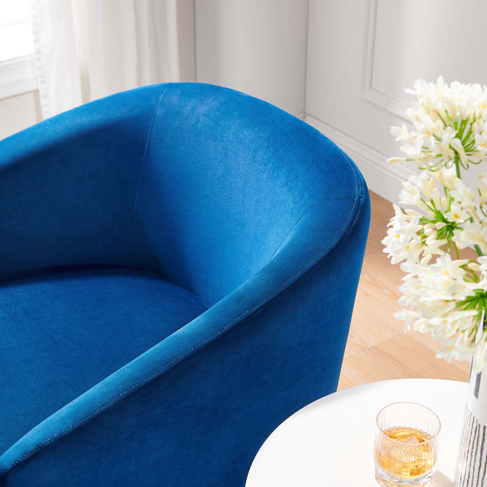 Close-up of the seam detail and curved arm on the Noelle Swivel Chair in navy velvet
