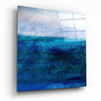 Blue and teal abstract seascape tempered glass wall art viewed at an angle showing glossy surface
