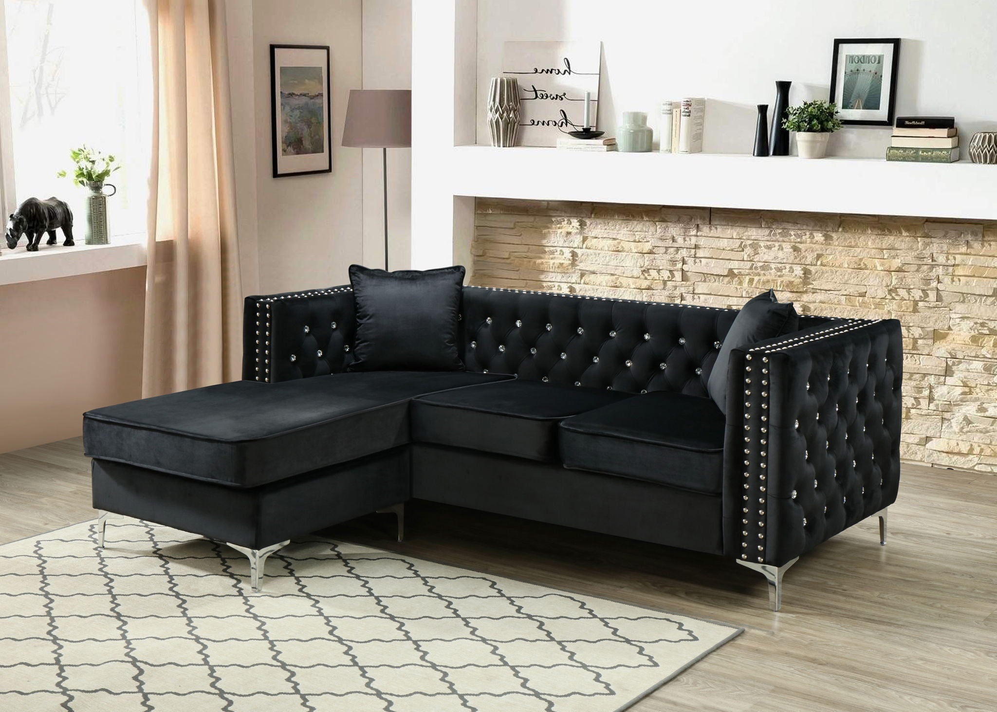 Black velvet sofa chaise with crystal tufting styled against a stone accent wall