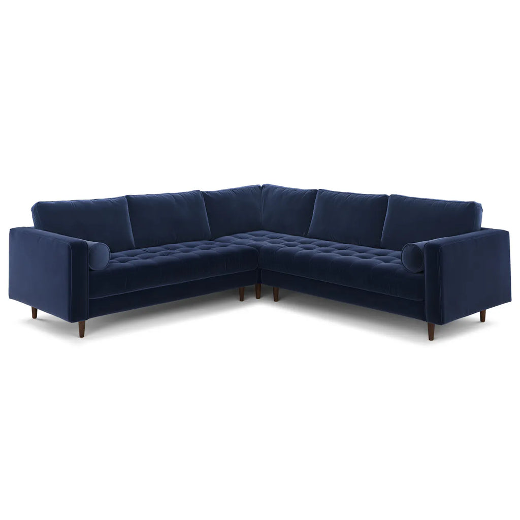 Full front view of the navy velvet corner sectional with tufted bench seat and bolster pillows