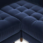 Overhead detail of diamond-tufted navy velvet bench seat and tapered wood leg on the Simone Sectional