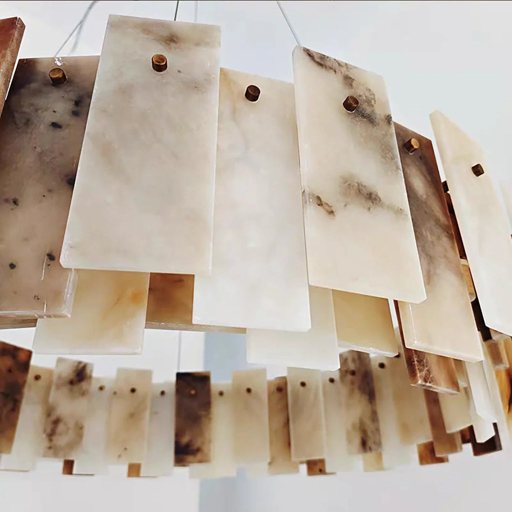 Close-up of overlapping alabaster stone panels showing natural veining and brass pin construction
