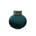 Round peacock green porcelain vase with a gold-banded neck, displayed on a wood console against a neutral gray backdrop