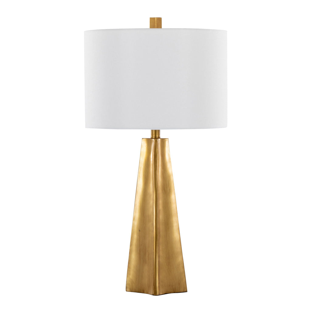 Gold faceted obelisk-base table lamp with a white linen drum shade, shown against a white background