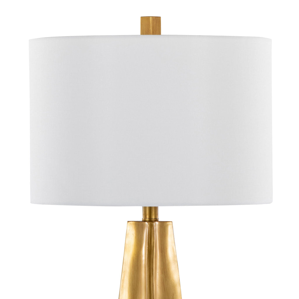 Close-up of the white linen drum shade and brass neck connection on the gold table lamp