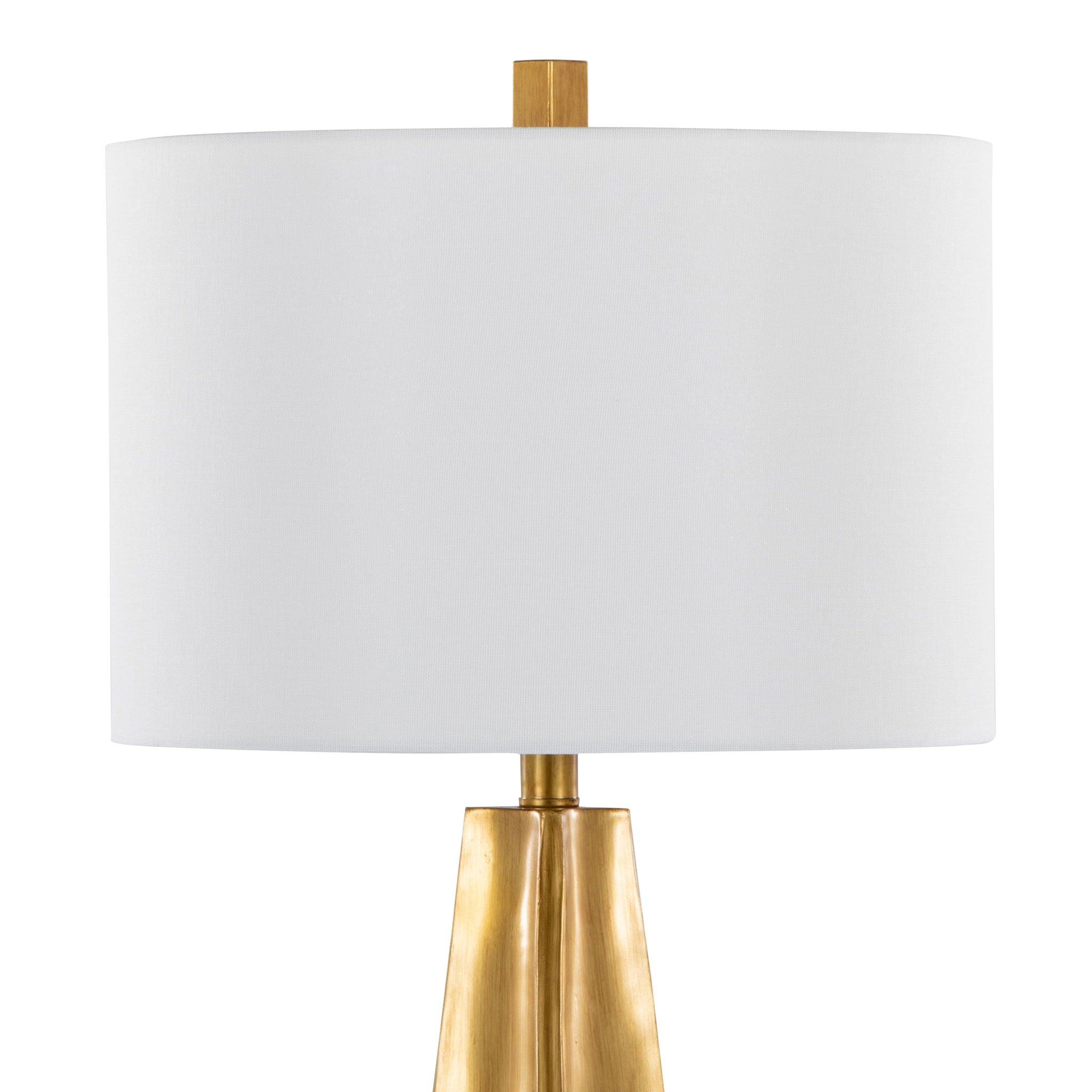 Close-up of the white linen drum shade and brass neck connection on the gold table lamp