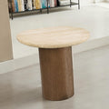 Round travertine side table with cylindrical oak base styled in a living room near a bookshelf