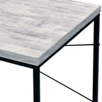 Close-up of the Beau Writing Desk's wood-grain top edge meeting the black iron frame and crossbrace