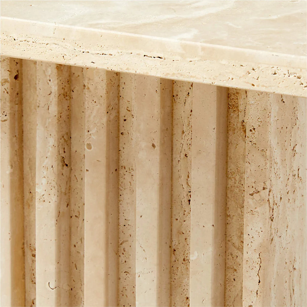 Close-up of the Fontaine Side Table's hand-carved fluted travertine base showing natural stone texture