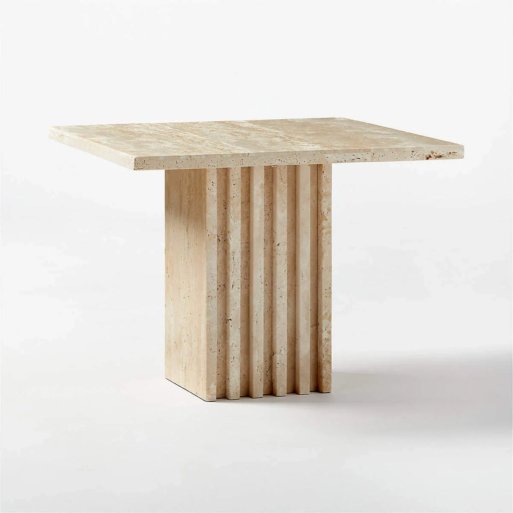 Honed travertine side table with fluted pedestal base shown in profile on a white background