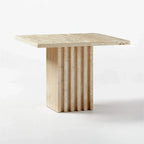 Honed travertine side table with fluted pedestal base shown in profile on a white background