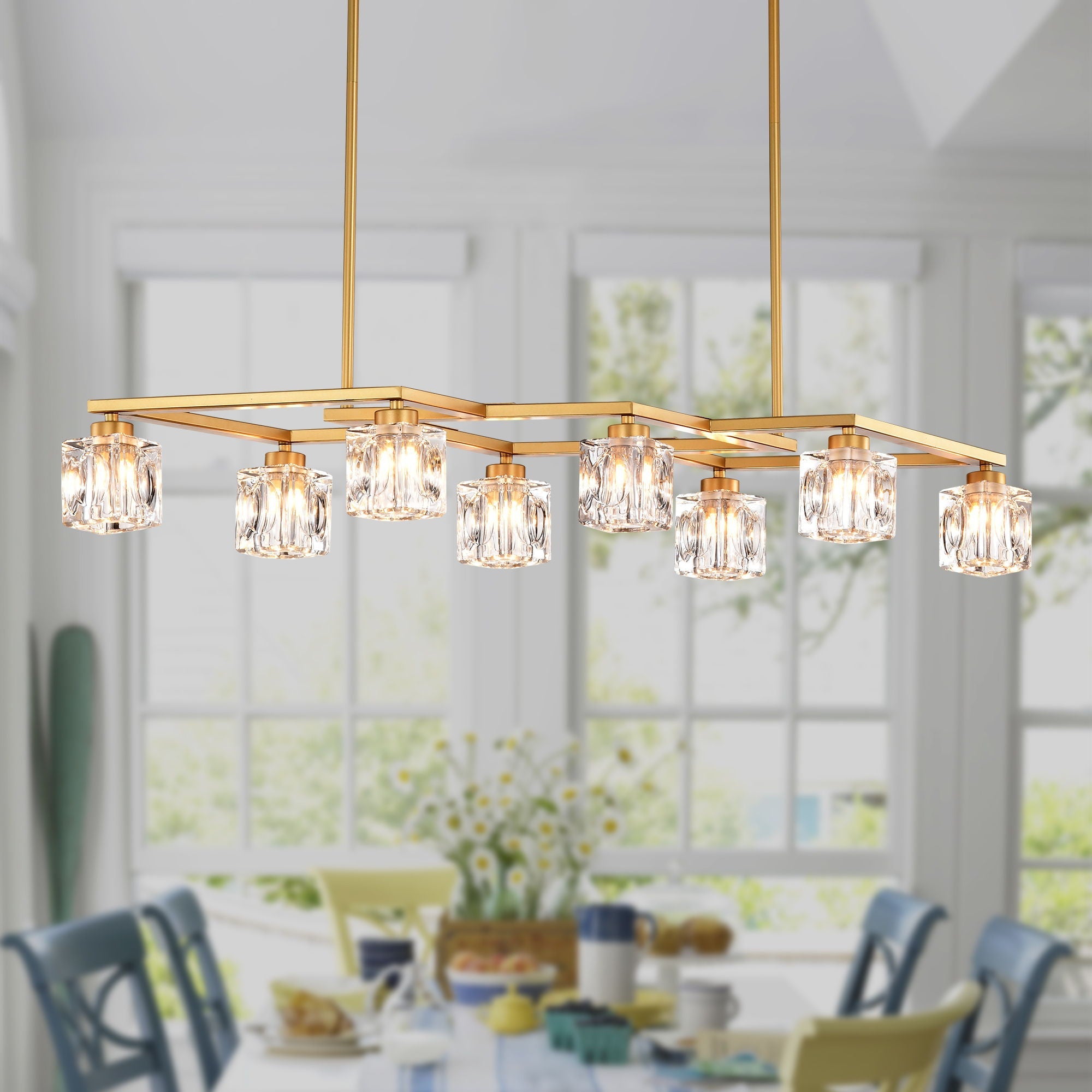 Matte gold geometric chandelier with crystal light cubes illuminated over a dining table