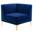 Navy channel-tufted velvet corner chair with gold metal legs, shown against a white background