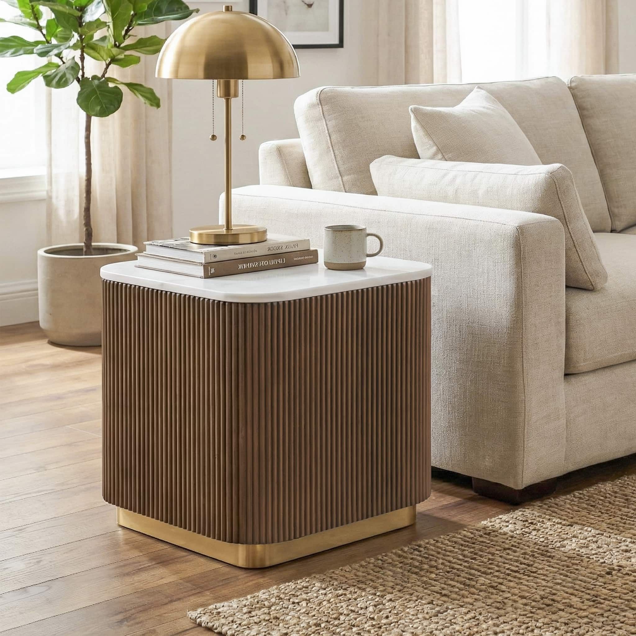 Marble-top reeded end table styled beside a linen sofa with a brass lamp and books