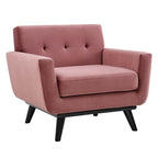 Dusty rose velvet tufted armchair with black wood splayed legs, shown at a front angle