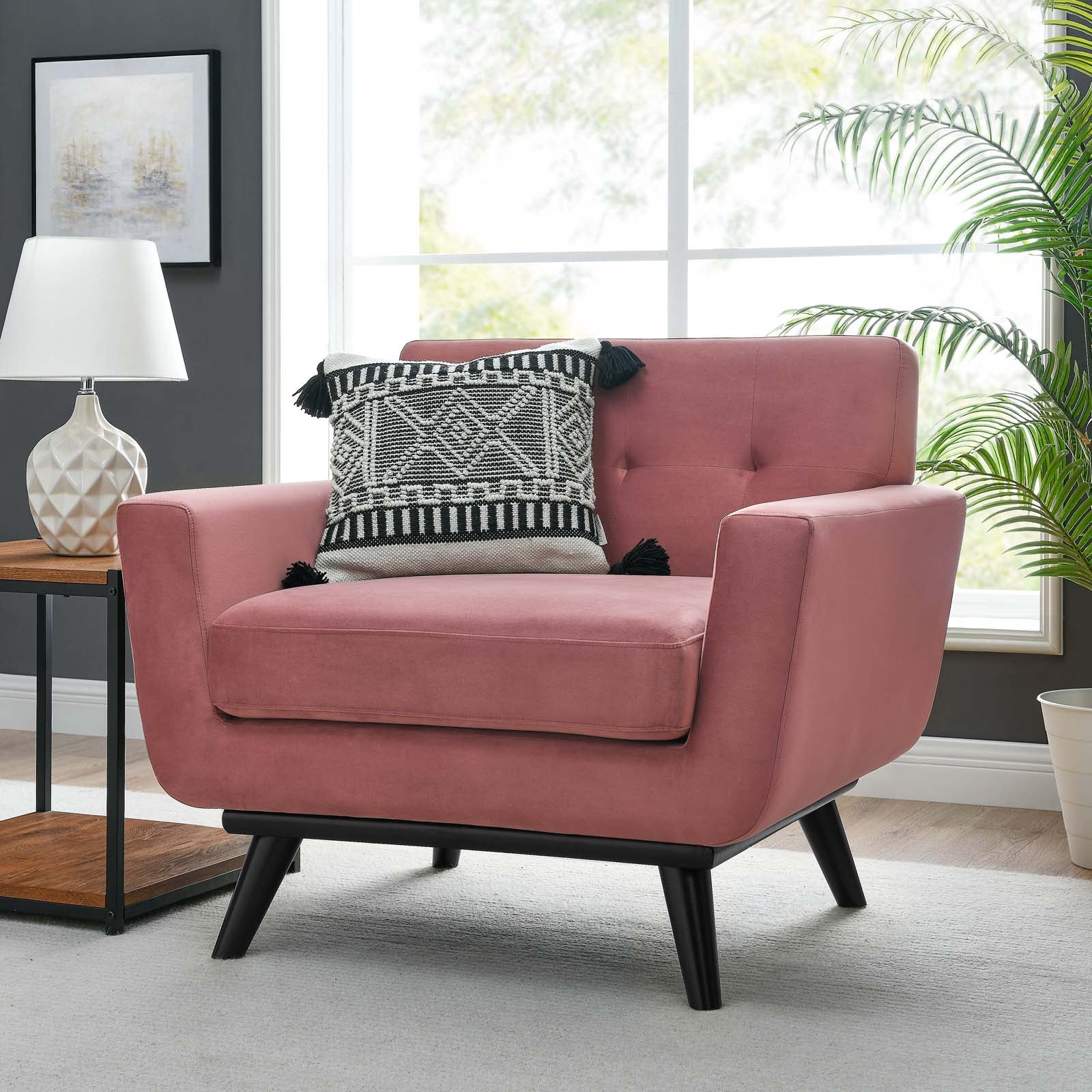 Dusty rose velvet armchair styled beside a window with a patterned accent pillow