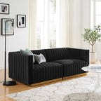 Black velvet channel-tufted loveseat styled with teal and gray accent pillows in a living room