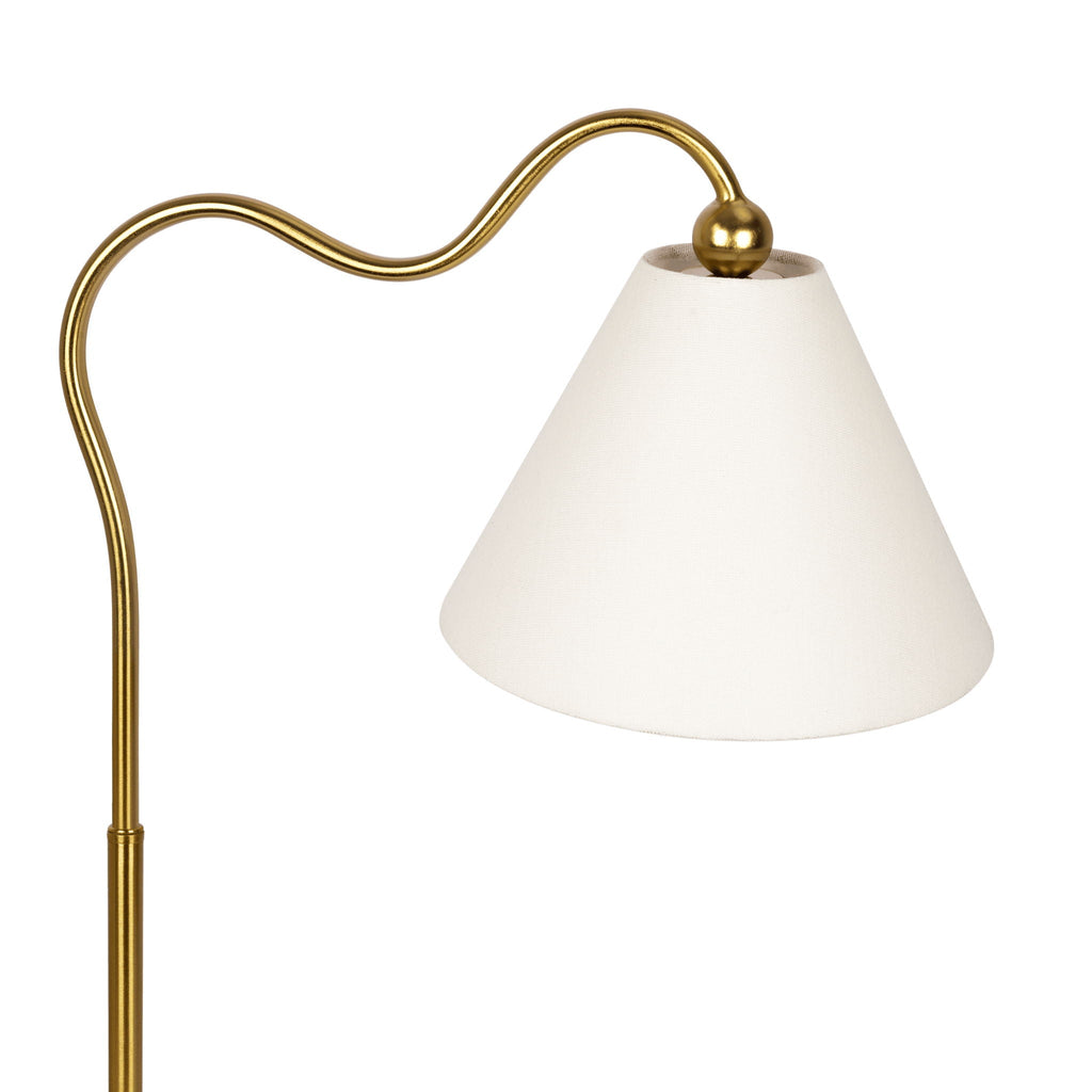 Close-up of the Margaux Table Lamp's curved brass arm meeting a triangular white drum shade