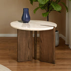 Round travertine side table with notched ash tripod base styled beside a potted plant