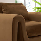 Title: The Odile Armchair | Full Sculptural Silhouette
Alt Text: Cognac velvet armchair with continuous curved arms on a white background